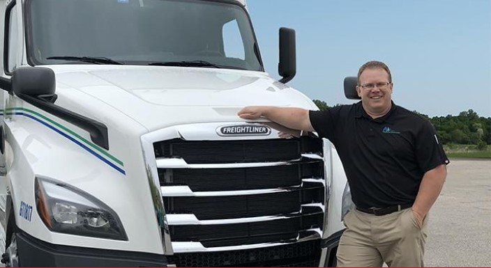 CDL truck driver standing next to a Freightliner with TVC Pro-Driver CDL ticket protection