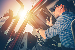Водитель грузовика с защитой билетов CDL за рулем в солнцезащитных очках
