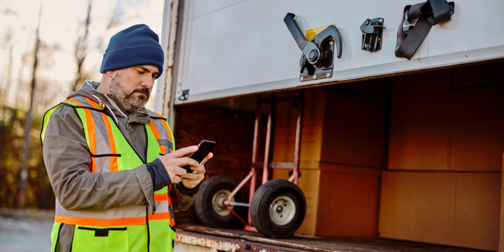 Chauffeur de camion vérifiant son téléphone