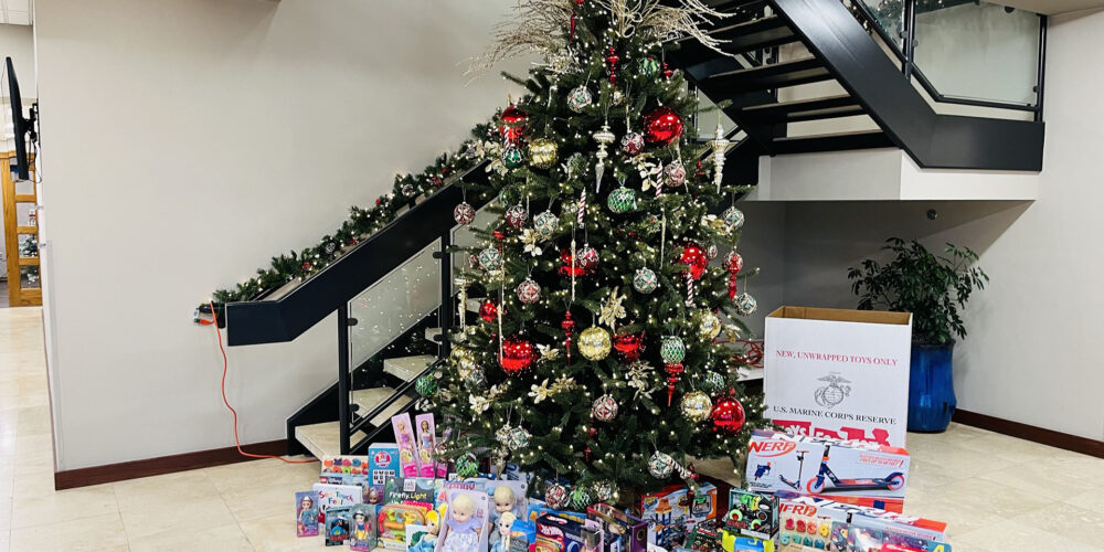 Árbol de Navidad con regalos debajo en el vestíbulo de la empresa TVC